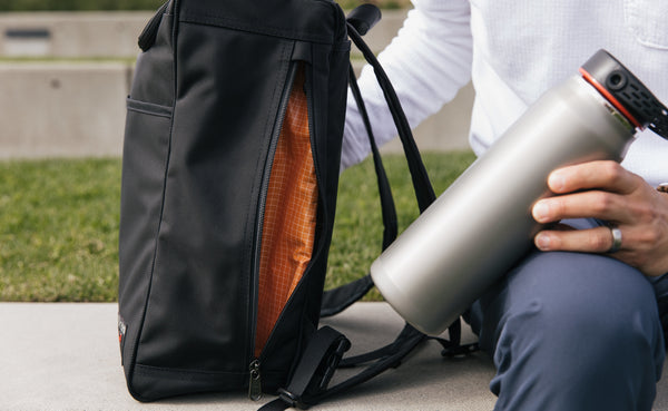 A waterbottle next to the large exterior pocket of the Cambiata.